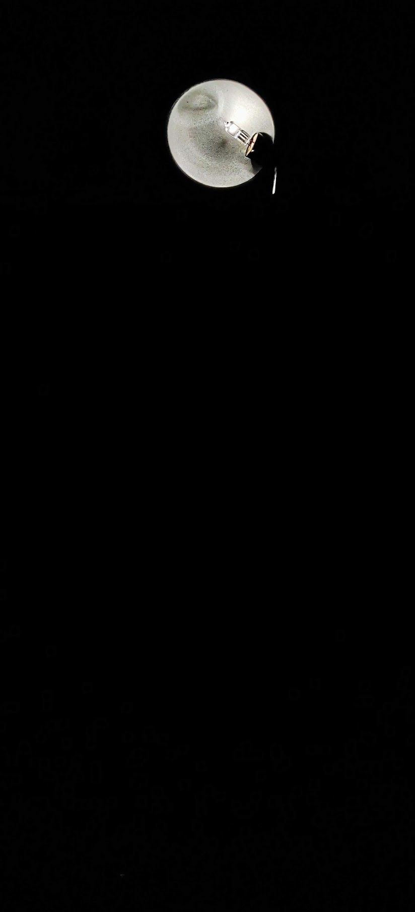 A single lamp suspended in deep darkness